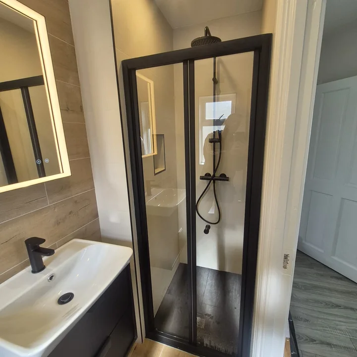 Compact shower room renovation with black framed shower enclosure