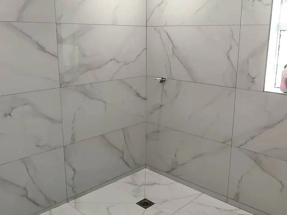 Marble-effect tiled shower with prepared drainage