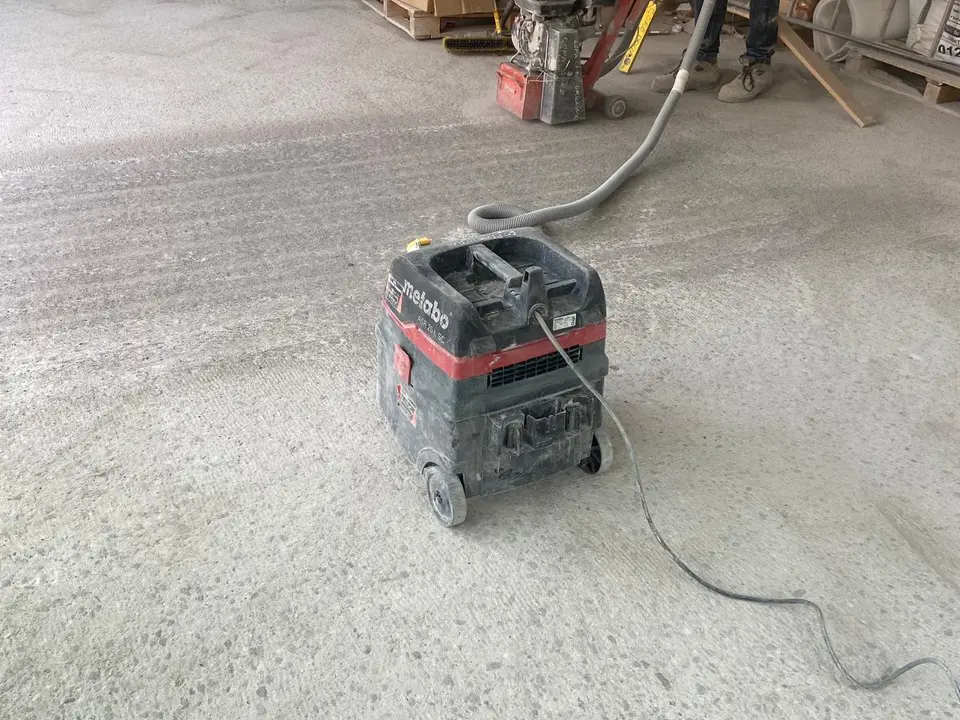 Floor scabbling equipment preparing an industrial concrete surface