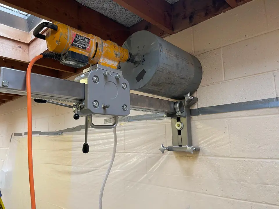 Wall-mounted core drilling rig creating a precise opening