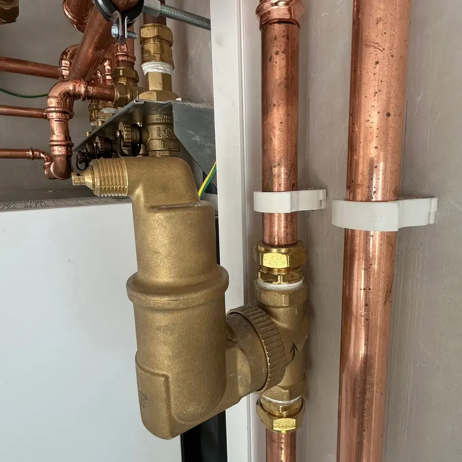 Close-up of heating-system copper pipework and valve