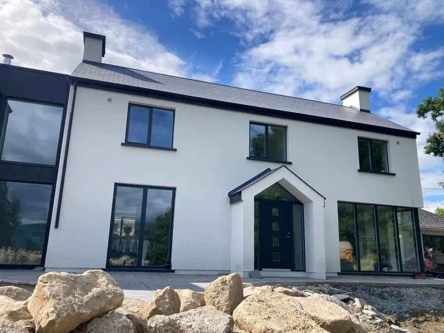 Completed modern home renovation with white render and dark exterior cladding