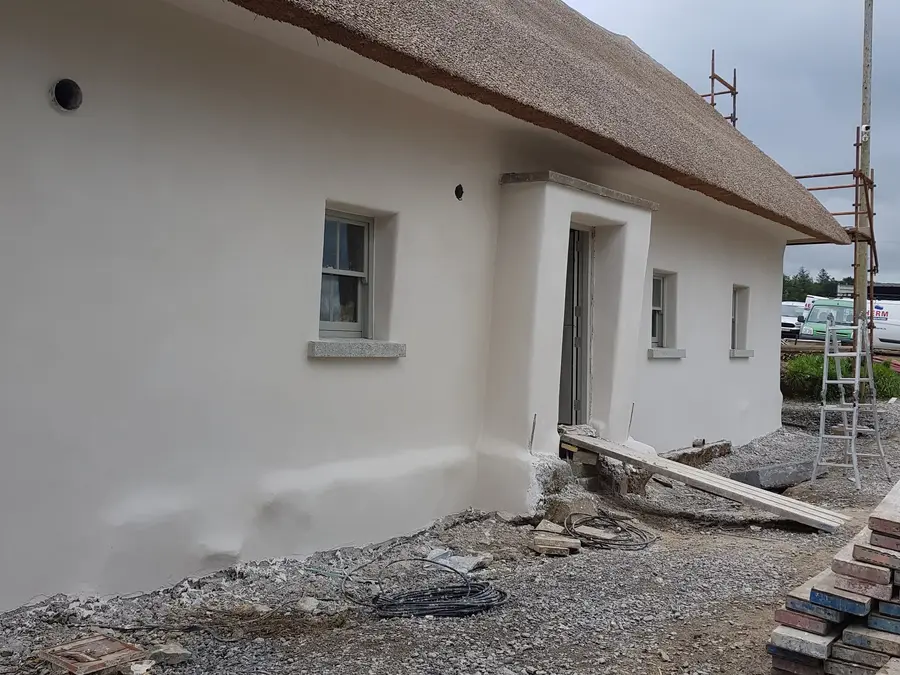 Restored cottage exterior with smooth white render
