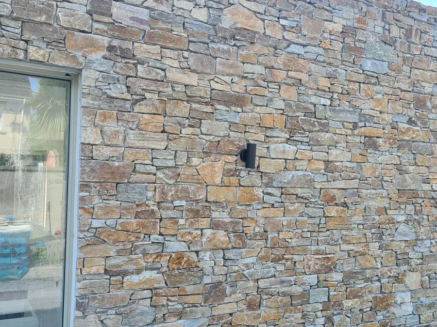 Restored natural stone wall beside a window