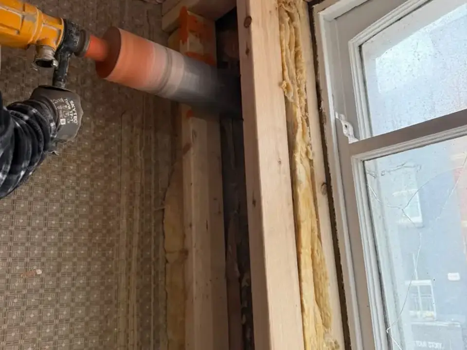 Core drilling a service opening beside a window