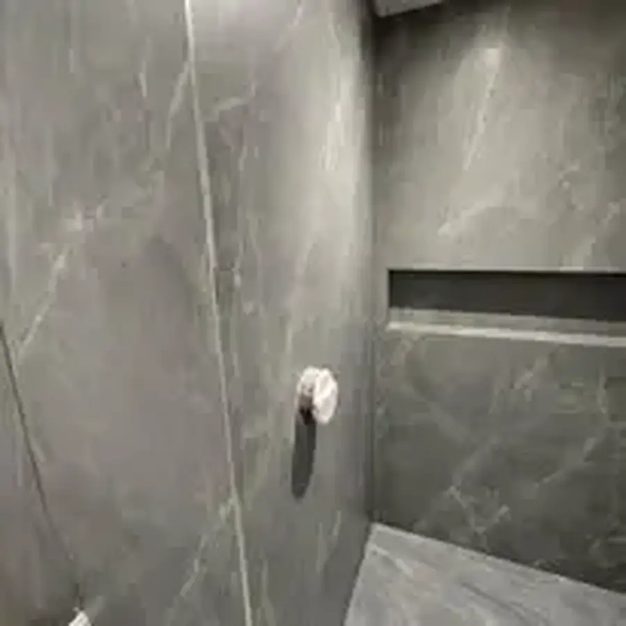 Large-format tiled shower wall with recessed shelf