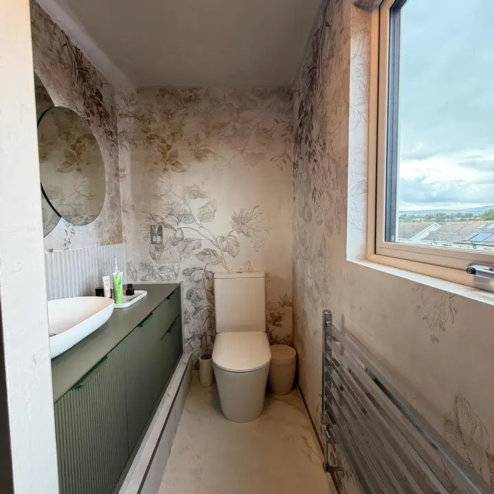 Bathroom renovation with green vanity, toilet and tiled finish by PrimeLine Plumbing Solutions