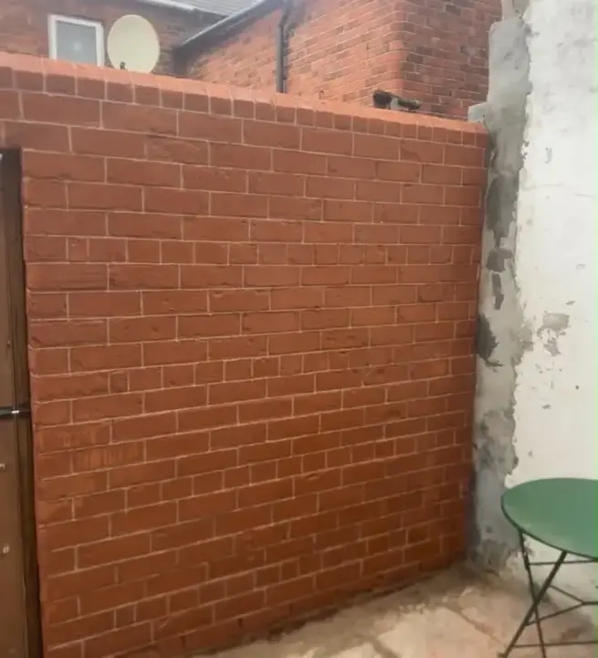 Rebuilt brick garden wall with penny-roll pointing by Rigney Restoration