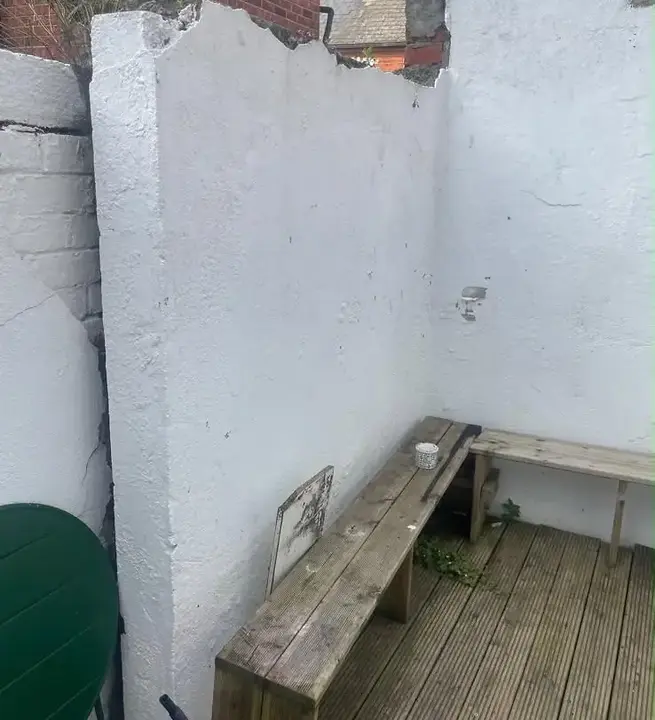 Damaged rendered garden wall before rebuilding by Rigney Restoration